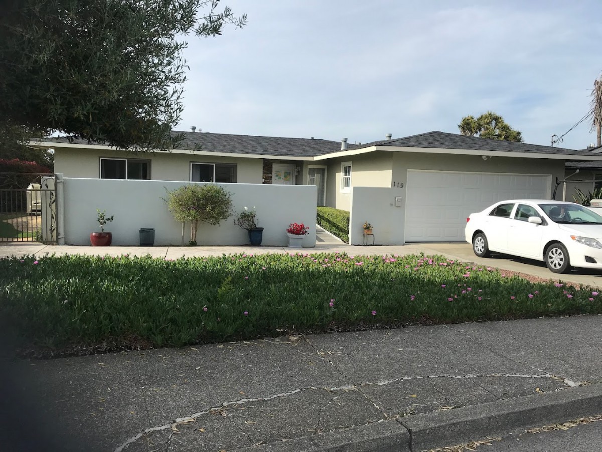 A suburban house with a driveway and a parked car.