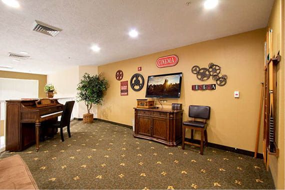 Cozy living room with a piano, television, and decorative wall art.