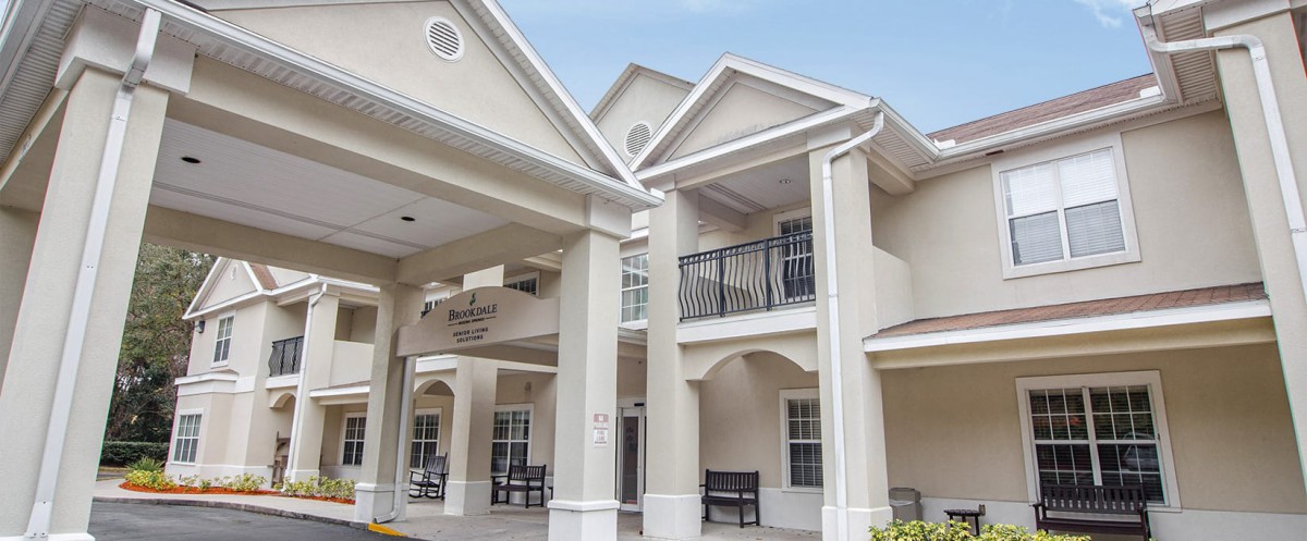 A residential building with prominent columns and a covered entrance.