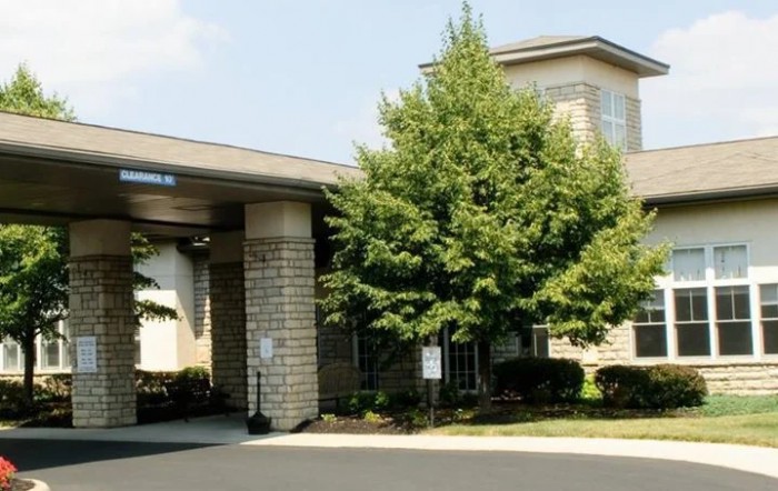 A view of a building's entrance with trees and landscaping.