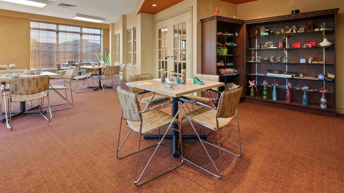 A cozy dining area with modern wooden furniture and ample natural light.