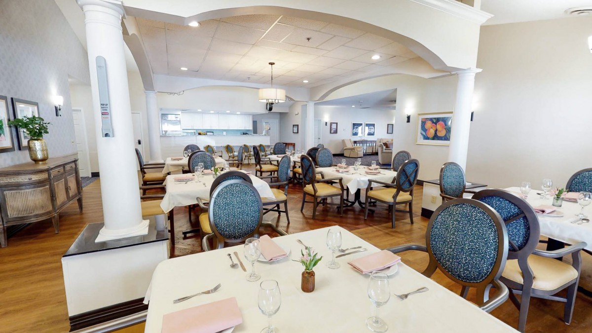 An elegant restaurant dining room with neatly arranged tables and chairs, featuring stylish interior decor.