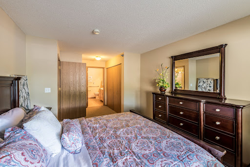 A cozy bedroom featuring a beautifully made bed and elegant wooden furniture.