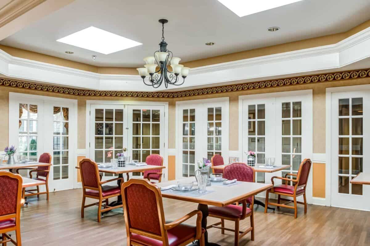 A spacious dining room with elegant furnishings and plenty of natural light.