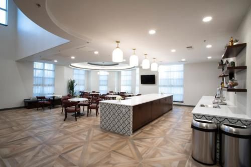 A modern kitchen and dining area with stylish lighting and wooden flooring.