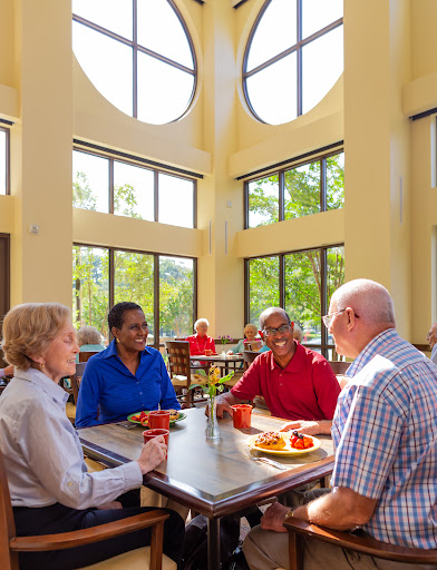 A group of seniors enjoying a meal together in a bright, inviting dining space.