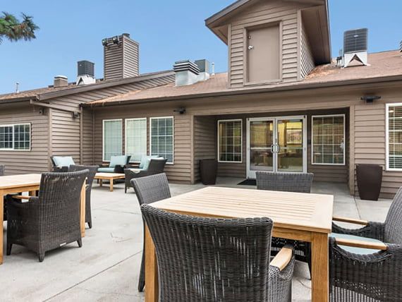 A spacious patio with comfortable outdoor furniture and a modern building exterior.