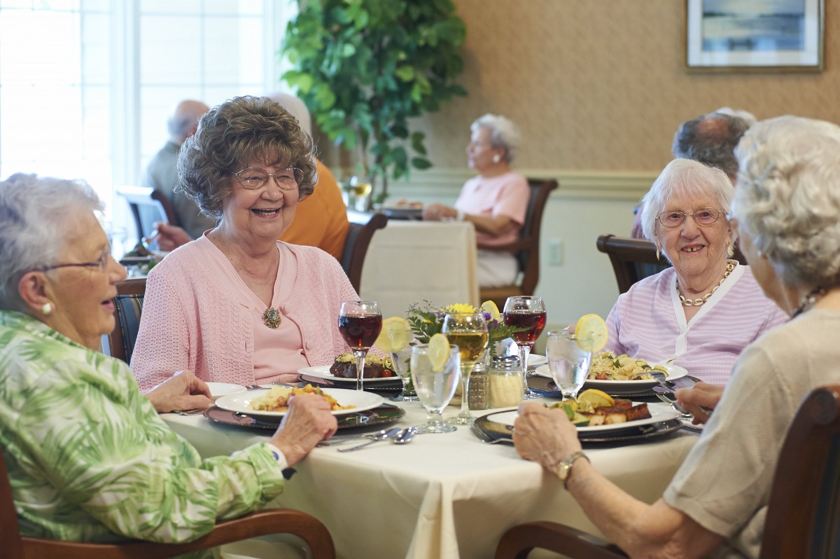 A group of elderly women enjoying a meal together in a cozy dining setting.