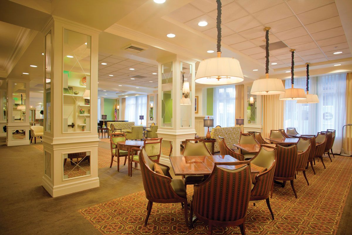A warmly lit dining area with elegant decor and seating arrangements.