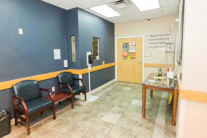 A clean and orderly waiting room in a medical clinic with chairs and a small table.