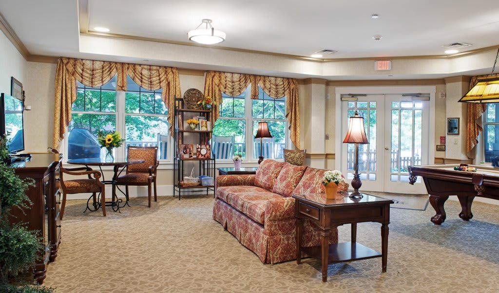 A cozy living room with a sofa, decorative curtains, and warm lighting.