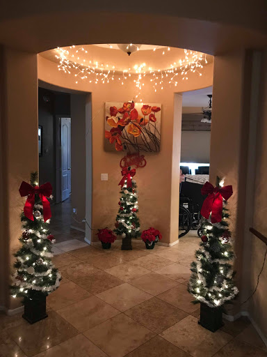 A beautifully decorated entryway adorned with Christmas trees and twinkling lights, creating a warm holiday ambiance.