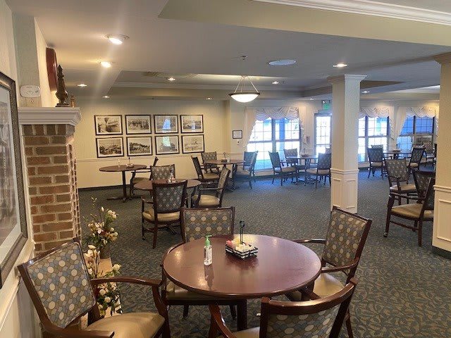 A spacious dining area with tables and chairs, featuring elegant decor and warm lighting.