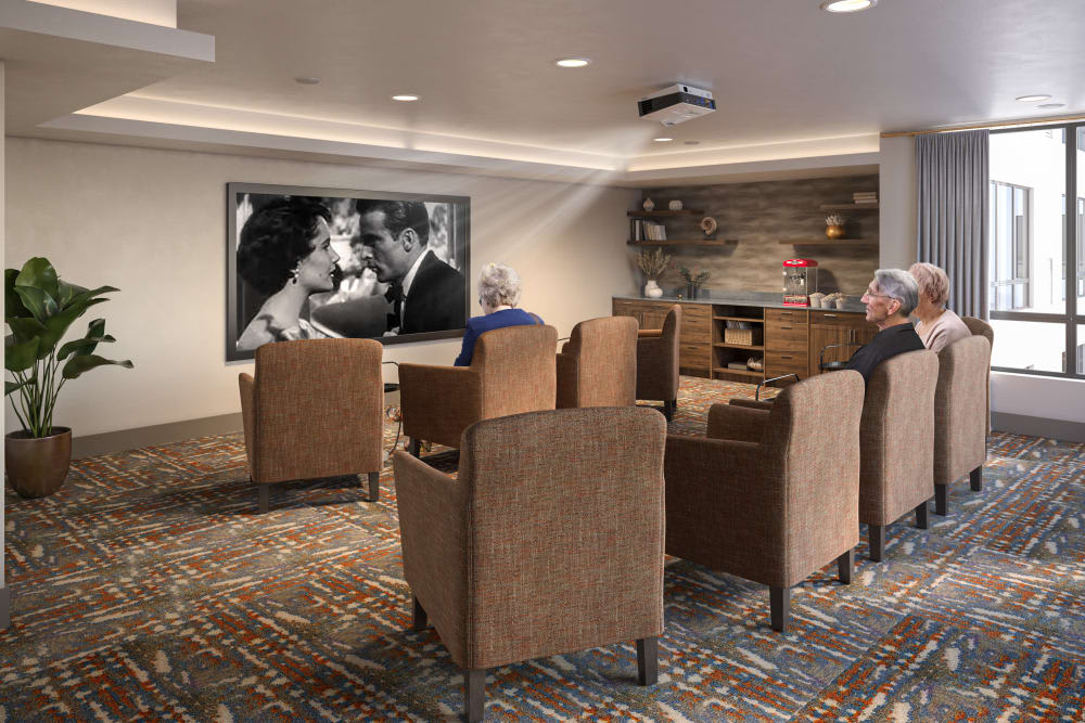 Seniors enjoying a classic black and white film in a cozy movie room.