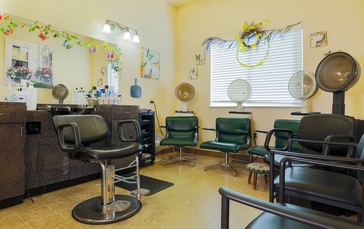 A cozy salon interior featuring styling chairs, mirrors, and hairdressing equipment.