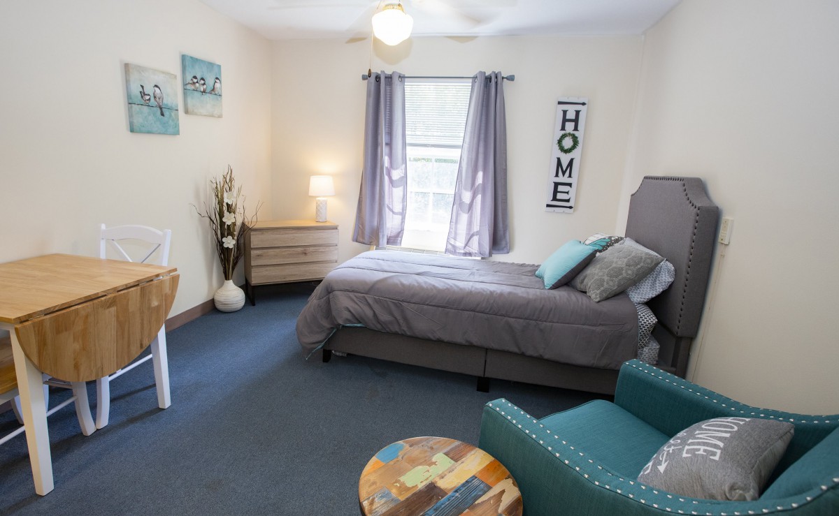 A cozy and modern bedroom with a comfortable bed, armchair, and stylish decor.