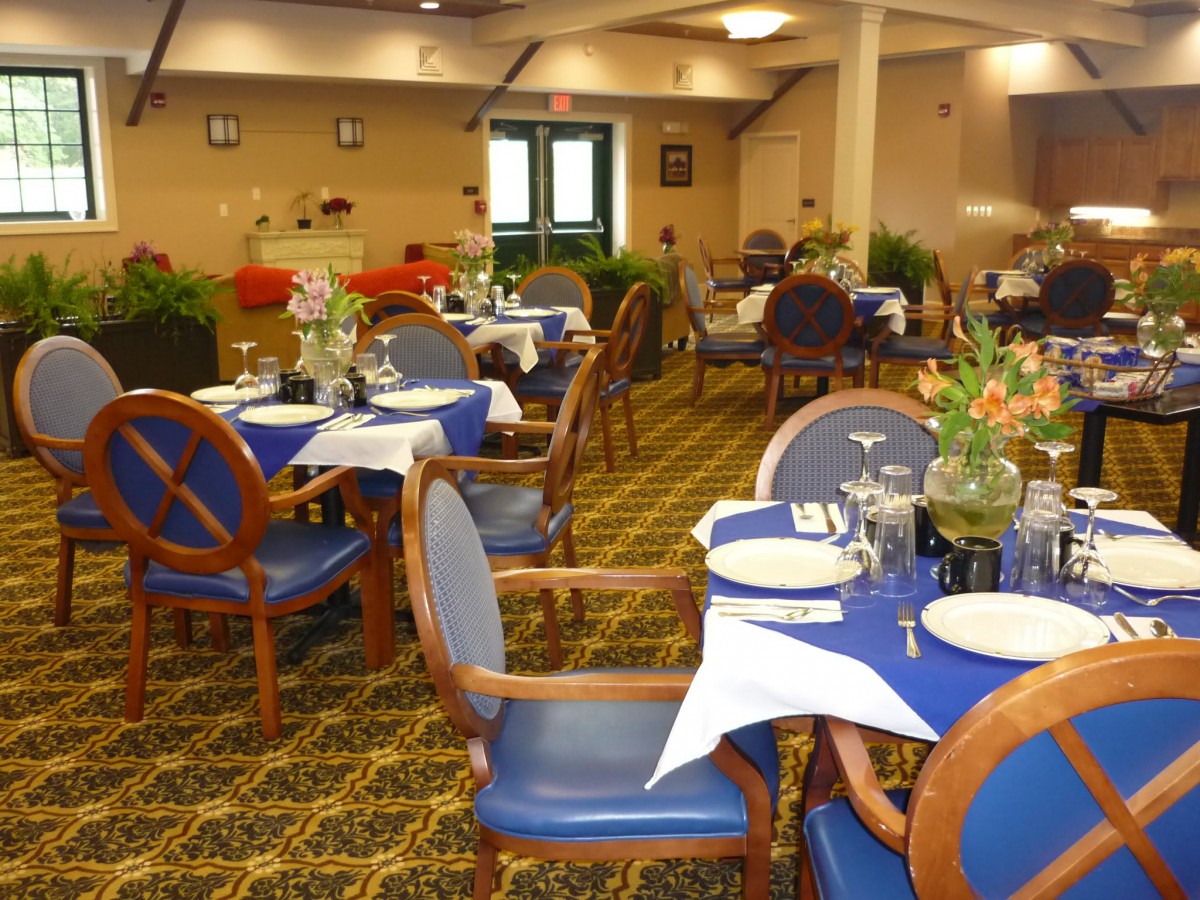 A well-arranged dining area with blue-themed table settings and comfortable seating.