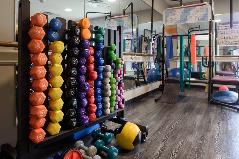 A well-equipped gym with colorful dumbbells and various fitness equipment.