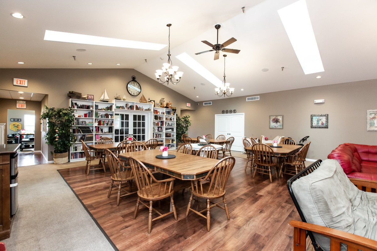 A cozy dining room with wooden furniture and ample natural lighting.