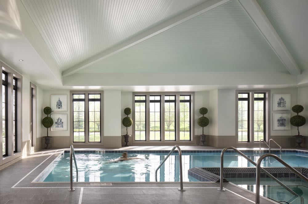 A luxurious indoor pool with elegant decor and ample natural light.