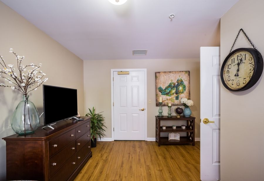A cozy living room with a television, wooden floors, and tasteful decor.