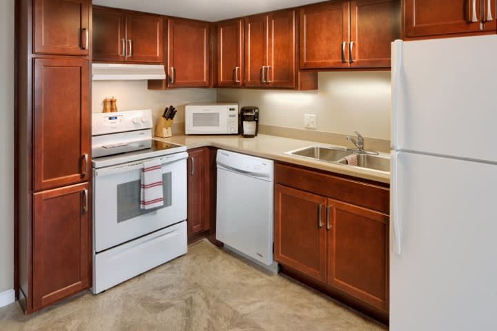 A modern kitchen with wooden cabinets and various appliances.