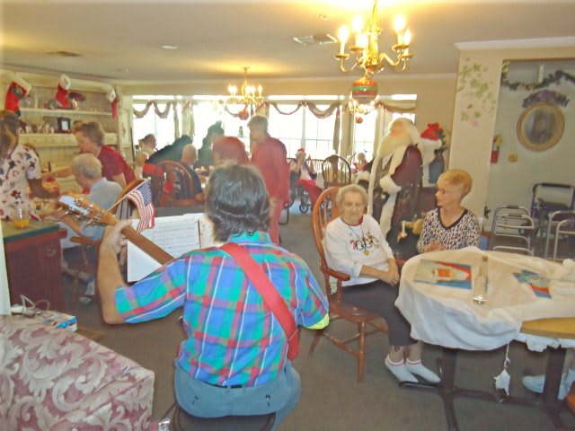 A musician entertains a group of elderly people during a social gathering.