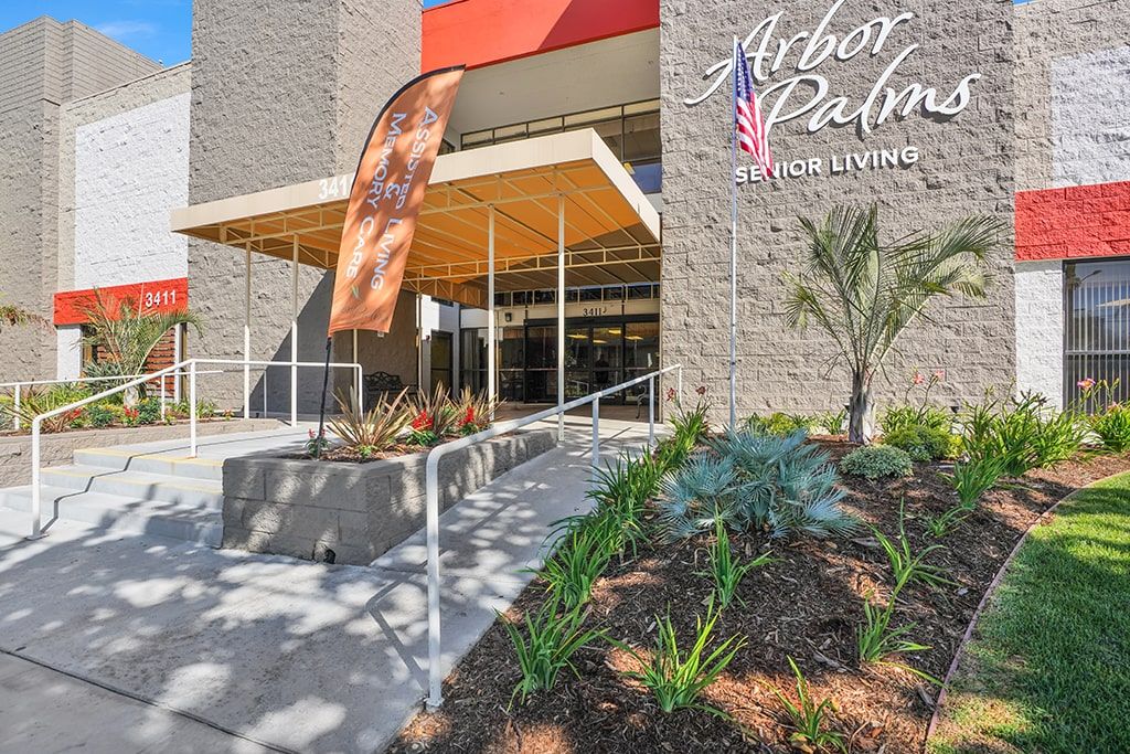 A modern building entrance with landscaping and clear signage for Arbor Palm.