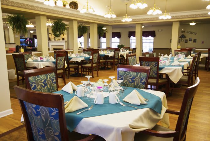 An elegant dining room setting with neatly arranged tables and chairs, featuring formal table settings.