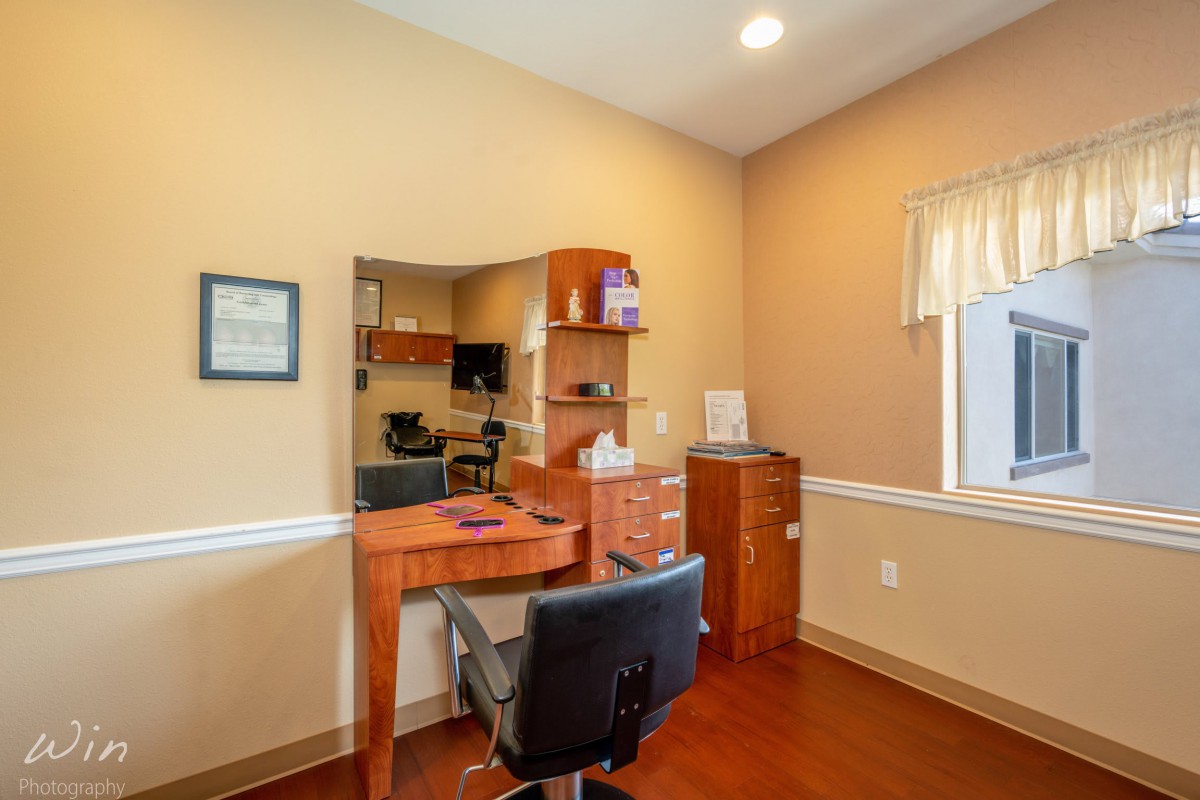A small office space featuring a desk, chair, and shelves.