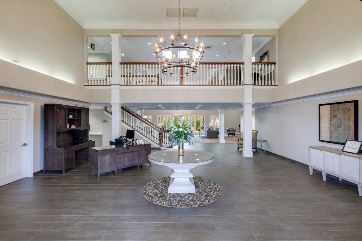 A spacious hotel lobby with elegant decor and a large chandelier.