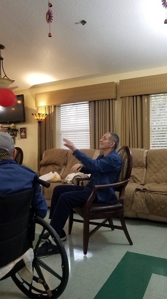 Elderly individuals engaging in a balloon activity indoors.