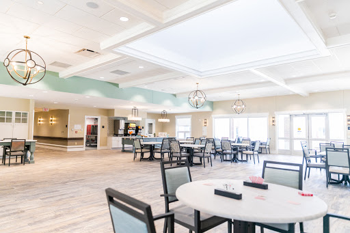A modern, spacious dining area designed for community gatherings, featuring elegant furniture and ample natural light.