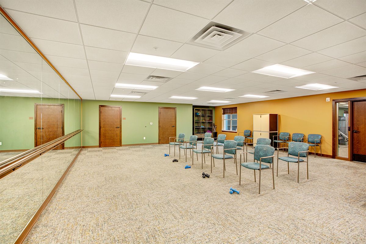 An empty classroom with chairs arranged in rows on a carpeted floor.