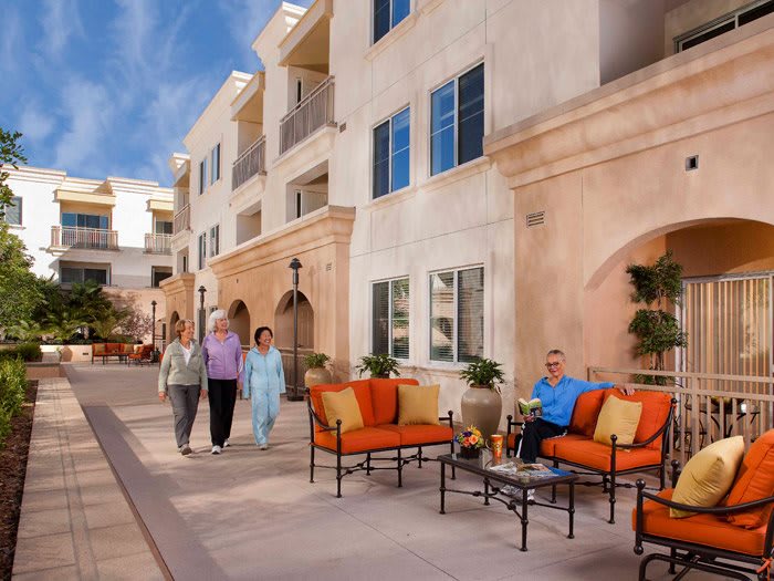 Seniors enjoying a leisurely day at a retirement community, featuring comfortable outdoor seating and a pleasant atmosphere.