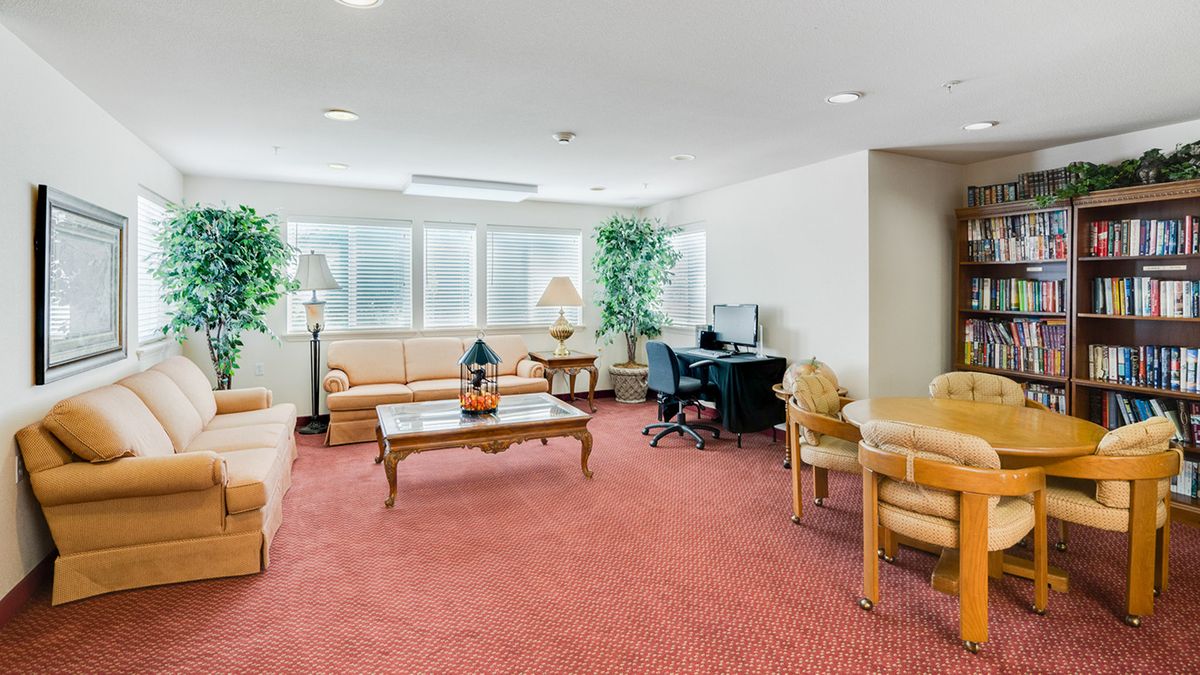 A spacious lobby with seating, computer desks, and indoor plants.