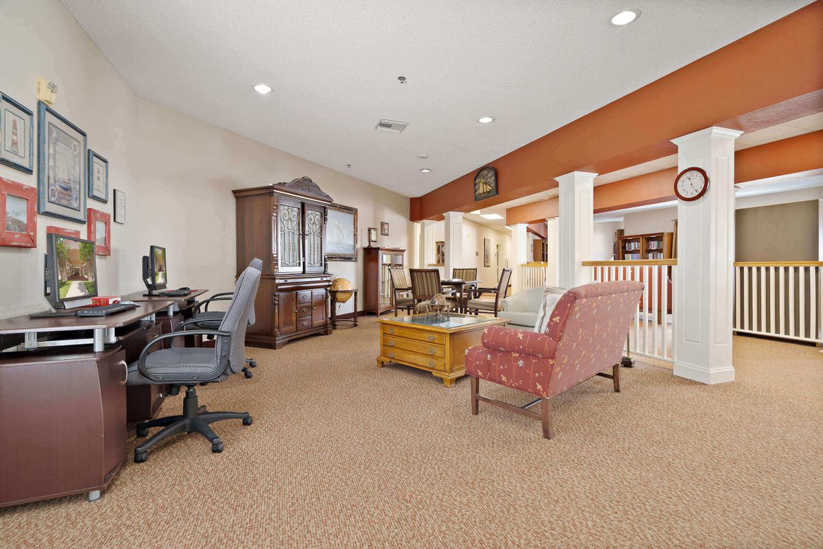 A cozy living room with a seating area and a computer desk.