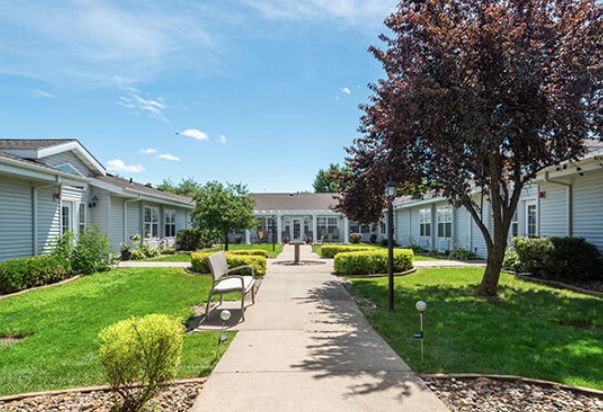 A well-maintained building surrounded by a landscaped garden with a pathway and benches.