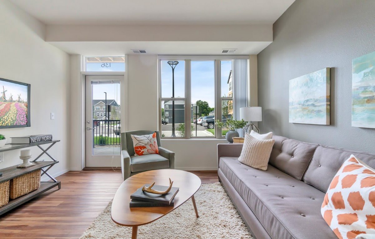 A modern living room with stylish furniture and a large window view.