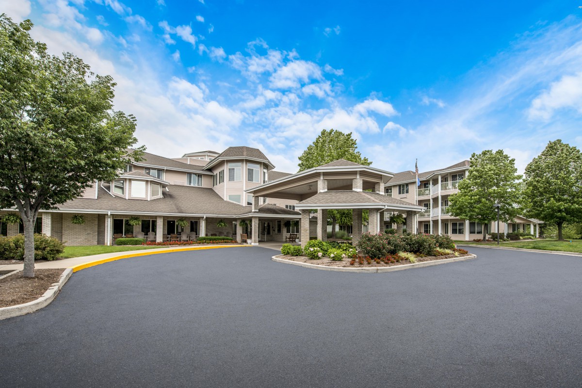 A large residential building with a circular driveway and landscaped entrance.