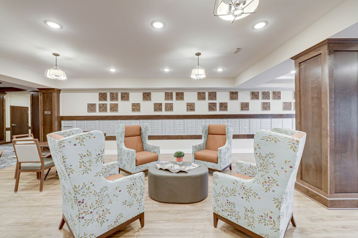 A modern seating area with patterned chairs and a central table, illuminated by overhead lighting.