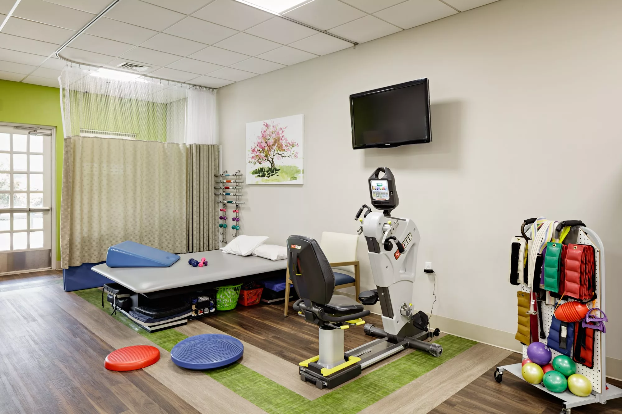 A physical therapy room equipped with various rehabilitation tools and a treatment table.