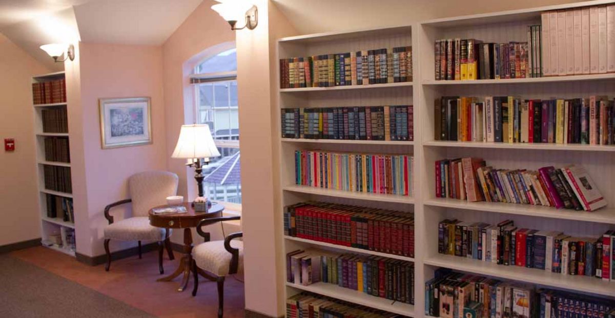 A cozy reading nook with a well-stocked bookshelf and comfortable seating.