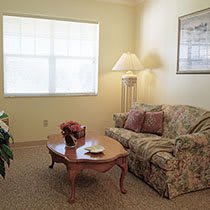 A cozy living room with a patterned sofa, wooden coffee table, and soft lighting.