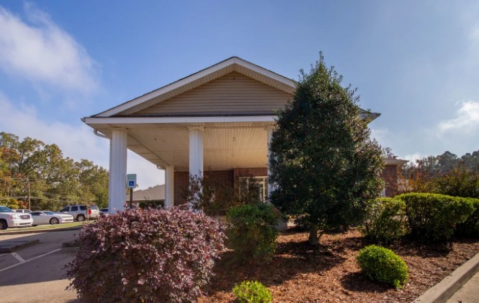 Front view of a building with landscaped garden and clear sky.