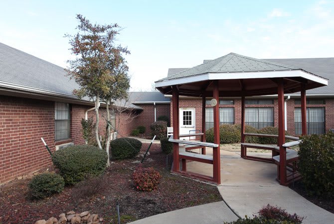 A well-maintained courtyard features a gazebo and landscaped garden, surrounded by buildings.