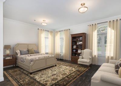 A spacious and elegantly decorated bedroom with a large bed, plush carpet, and a cozy reading nook.