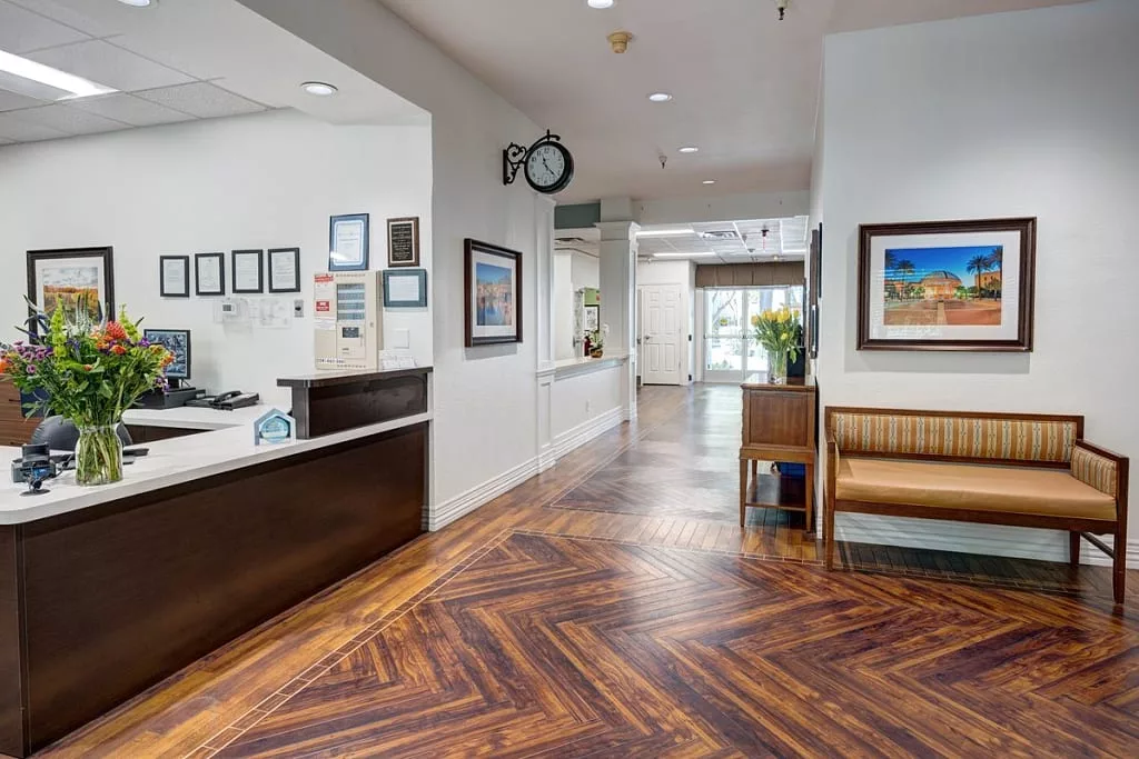 A modern reception area with wood flooring and a comfortable waiting space.
