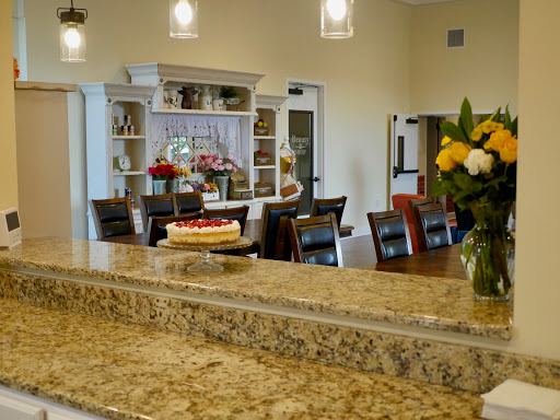A beautifully designed kitchen and dining area featuring a granite countertop, elegant lighting, and decorative flowers.