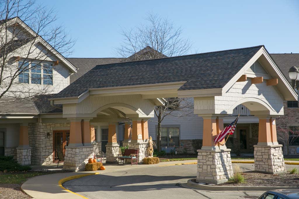 The image shows the entrance of a residential building on a sunny day.